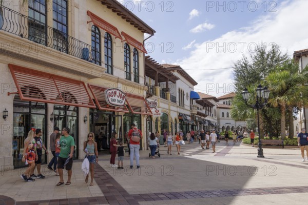 Shoppers and visitors walking past Ron Jon Surf Shop in Disney Springs at Disney World in Orlando, Florida, USA