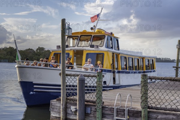 Water taxi boat with passengers approaching the dock of Fort Wilderness campground at Walt Disney World in Orlando, Florida, USA