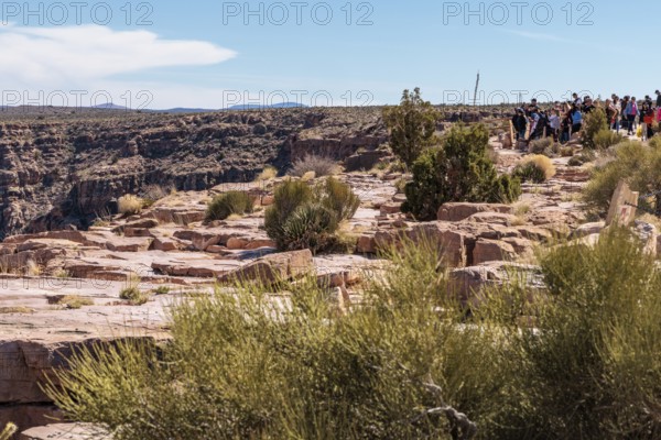 Visitors try to take photos of the canyon from a chained area nera the rim at the Eagle Point area of Grand Canyon West near Peach Springs, Arizona