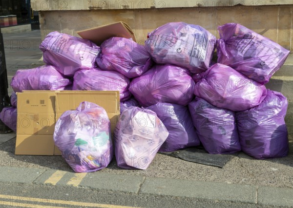 Council bags of rubbish waste piled on street corner, city of Bath, north east Somerset, England, UK