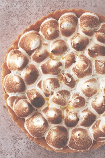 Lemon meringue cake, golden brown, toasted, on a light table, no people