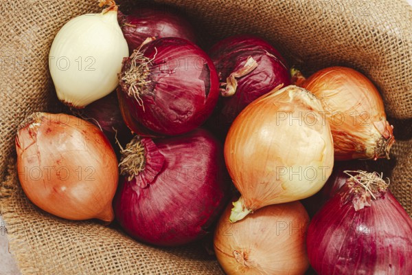Various varieties of onions, in a basket, on a wooden surface, rustic style, close-up, no people