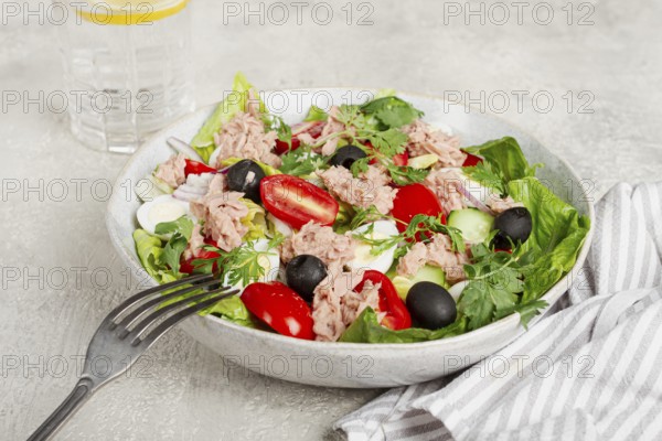 Salad with canned tuna, vegetable salad with quail eggs, lettuce and romaine leaves, red onion, cherry tomatoes, olives, keto food, healthy eating