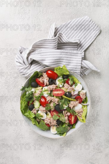 Salad with canned tuna, vegetable salad with quail eggs, lettuce and romaine leaves, red onion, cherry tomatoes, olives, keto food, healthy eating