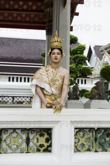 Thai traditionally and festively dressed young woman, Wat Pho, Bangkok, Thailand
