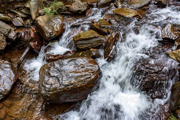 Small stream of clear water flowing between the rocks in Minas Gerais, Minas Gerais, Brazil
