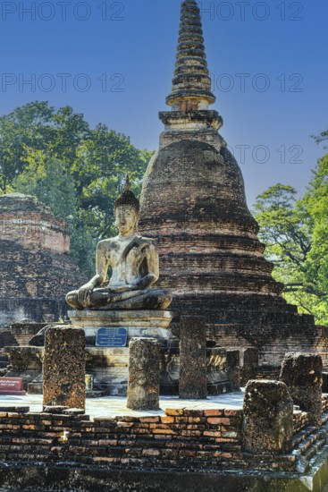Stone Buddha statue and historic temple tower, Prang, historical park, Sukhothai, Sukhothai province, Thailand