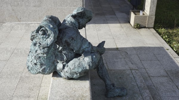 Stone figure of a seated pilgrim with backpack in the sun, pilgrims on the Caminho Portugues, Portugal, Spain