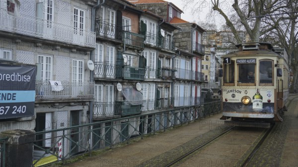 Historic tram runs along a street with old buildings, pilgrims on the Caminho Portugues, Portugal Porto, Portugal