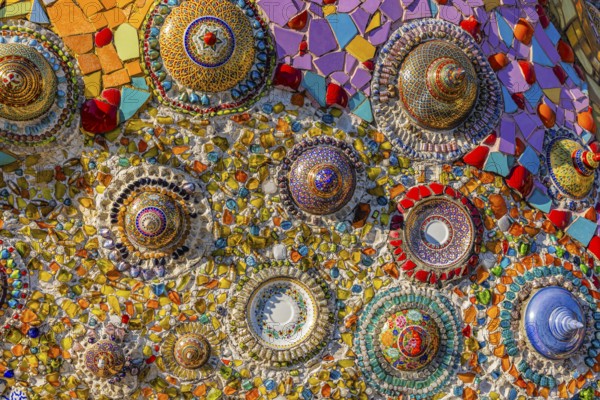 A wall decorated with colorful mosaic tiles and glass works of art, Buddhist temple complex Wat Phra That Sorn Kaew, Phetchabun province, Thailand