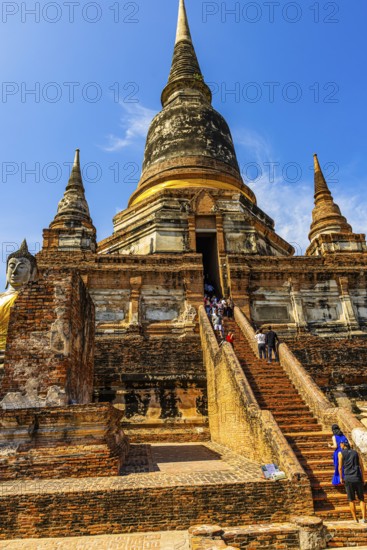 Visitors on steep stairs to the entrance of a temple tower, Prang, historic Buddhist temple complex, Ayutthaya, Thailand