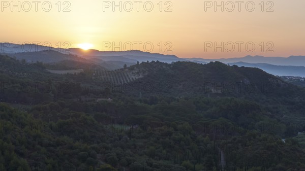 Wide landscape with hills at dusk, sunset behind the mountains, Hotel Europa, garden restaurant and view of the surrounding landscape, Olympia, Peloponnese, Greece