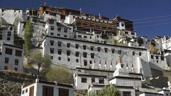Thiksey monastery, large ensemble of buildings with white walls and windows under blue sky, Indus Valley, trekking in Ladakh, Himalayas, India