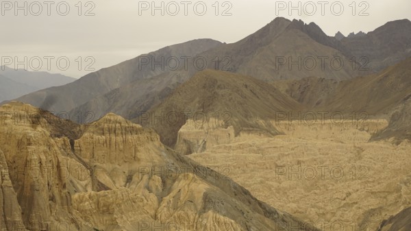 Wide mountain landscape with dramatic rock formations and valleys under a cloudy sky, trekking in Ladakh, Himalayas, India