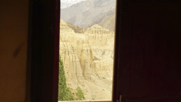 View from a dark window of a rocky, desert-like mountain landscape, trekking in Ladakh, Himalayas, India