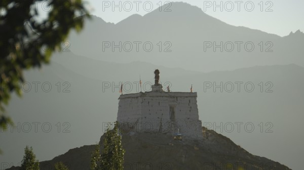 A secluded Buddhist sanctuary on a hill surrounded by mountains at dusk, Leh, trekking in Ladakh, Himalayas, India