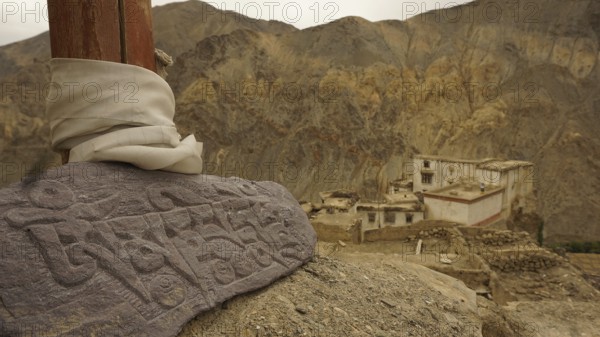 An engraved Mani stone in a mountainous landscape, near an ancient monastery, Leh, trekking in Ladakh, Himalayas, India