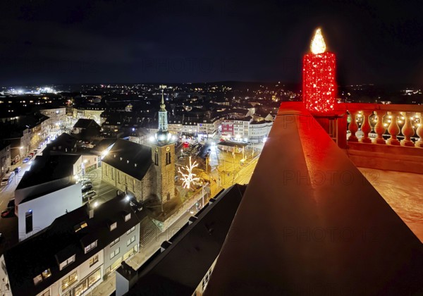 Large candle sculpture for Advent on the town hall tower in the evening with a view of St. John's Church, Witten, Ruhr area, North Rhine-Westphalia, Germany