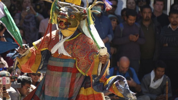 Masked dancer in traditional clothing in front of an audience in Leh, trekking in Ladakh, Himalayas, India