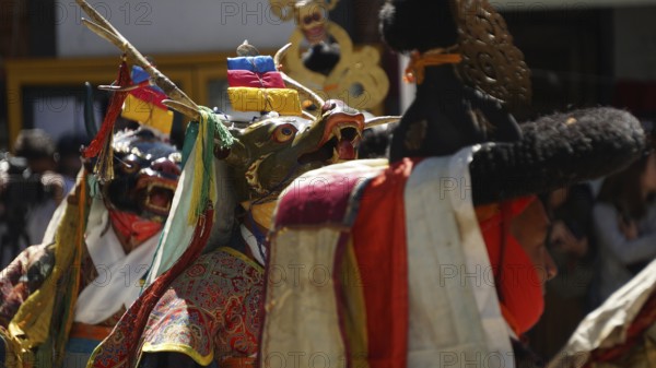 People wearing traditional masks and colorful costumes in a cultural ceremony in Leh, trekking in Ladakh, Himalayas, India