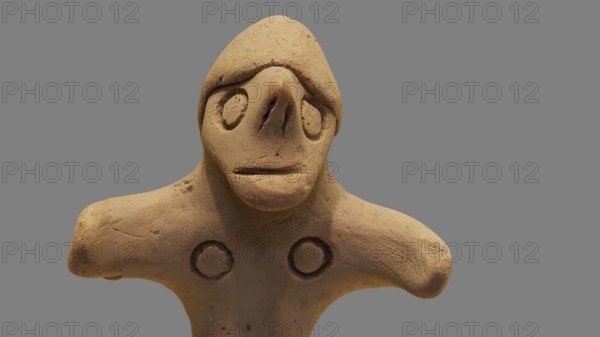 Anthropomorphic votive statuette, delicate clay sculpture with simple facial features on a light background, Olympia Archaeological Museum, Ancient Olympia, Olympia, Peloponnese, Greece