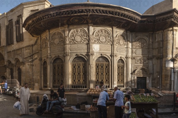 Cairo, Egypt. July 7th 2024 A local vegetable market in front of the ancient Sabil of Muhammad Ali near the Fatamid gate of Bab Zuweila in Darb al Ahmar, historical Cairo, Egypt