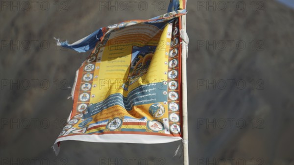 Detailed Tibetan prayer flag blowing in the wind in front of a mountain, trekking in Ladakh, Himalayas, India