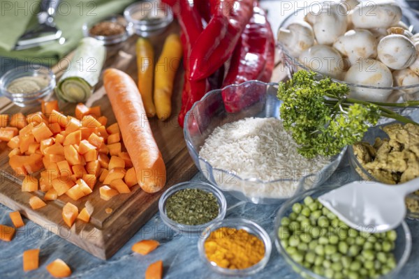 Fresh ingredients and spices such as peppers, peas, rice, mushrooms and sliced carrots