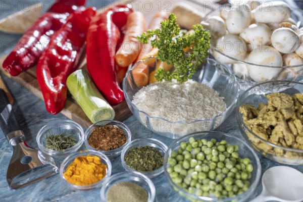 Various fresh ingredients and spices such as peppers, peas, rice, mushrooms and carrots