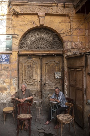 Cairo, Egypt. July 3rd 2024 Two old Egyptian men sit outside a café in Al-Darb Al-Ahmar district of Islamic Cairo, Egypt