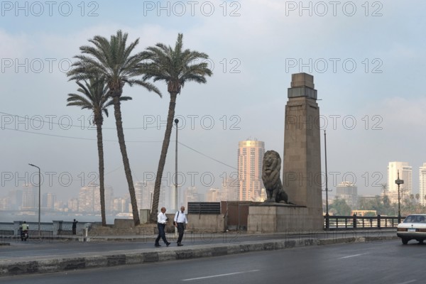 Cairo, Egypt. July 1st 2024 Two Egyptian men cross the Qasr El Nil Bridge during the early morning commute, Downtown Cairo, Egypt
