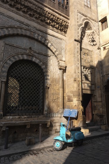 Cairo, Egypt. December 21st 2022 Vespa motor scooter outside Sabil-Kuttab of Katkhuda, in Al Muizz Street nr Khan El Khalili Bazaar in the old part of Islamic Cairo, Egypt