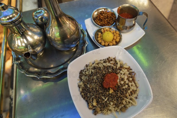 Koshary, kushari or koshari the most popular culinary dish in Egypt, a mix of pasta, rice, lentils, chickpeas and fried onions and topped with tomato and garlic sauce