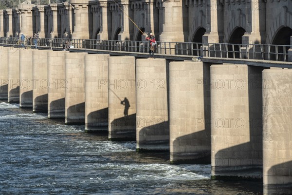 Qanater, Nile Delta. Egypt. December 18th 2022 Egyptian men fishing from the El Qanater Barrage, on the River Nile at the Delta Barrages, the Nile River divides into the Damietta and Western Rosetta branches