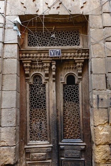 Cairo, Egypt. December 21st 2022 An antique wooden door of a house in the narrow alleyways of the old part of Islamic Cairo nr Khan el Khalili Bazaar, Al Muizz Street, Cairo, Egypt