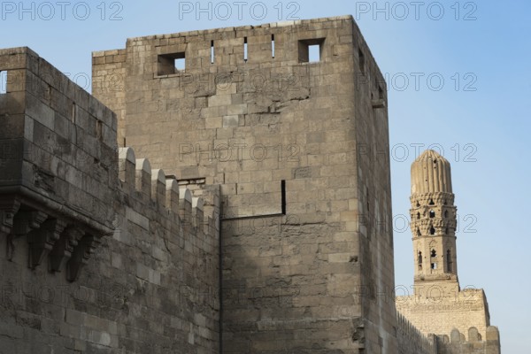 Minaret of the Al Hakim Mosque with the fortified defensive Northern walls of Islamic Cairo, near Bab El Futuh one of the ancient gates of the historical Egyptian city of Cairo, Egypt