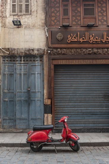 Cairo, Egypt, November 26th 2022 Very cool red Vespa motor scooter parked in the Islamic quarter of Cairo near the famous Khan el Khalili Bazaar, Egypt