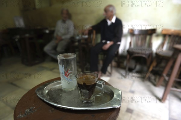 Cairo, Egypt. November 27th 2022 Traditional glass of Egyptian Arabic coffee on a tray in a local cafe in a side street of Cairo, coffee and tea are the most popular drinks in Egypt and the Middle East