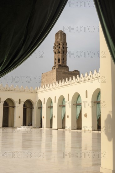 Minaret and courtyard of historic Mosque of al-Hakim, also known as Al-Anwar, named after Al-Hakim bi-Amr Allah. Just inside the Fatimid gate, Bab al-Futuh in Islamic Cairo, Egypt