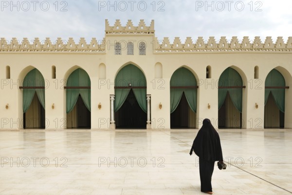 A Muslim women entering the prayer hall of historic Mosque of al-Hakim, also known as Al-Anwar, named after Al-Hakim bi-Amr Allah. Just inside the Fatimid gate, Bab al-Futuh in Islamic Cairo, Egypt