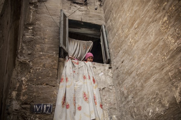 Cairo, Egypt. March 13th 2006 A young Egyptian girl in the window of a house in a poor neighborhood of Cairo, Egypt