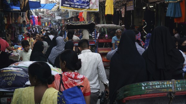 Dense crowd in a market scene with lots of rickshaws and hustle and bustle in a Muslim quarter of Delhi, India