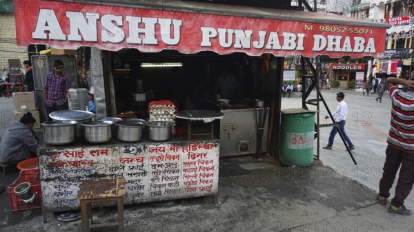 Small street restaurant in India with various pots and passers-by, Manali, Himachal Pradesh, India