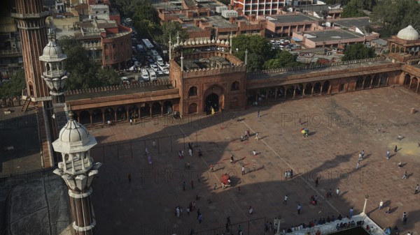 View from above of the Jama Masjid Historic Mosque in an urban setting with people and architectural structures, Delhi, India