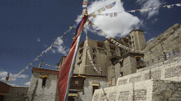 Traditional monastery with colorful prayer flags under blue sky, Ladakh, North India, Himalayas, India