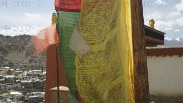 Colourful prayer flags move vividly in the wind against a mountain backdrop, Leh, Ladakh, North India, Himalayas, India