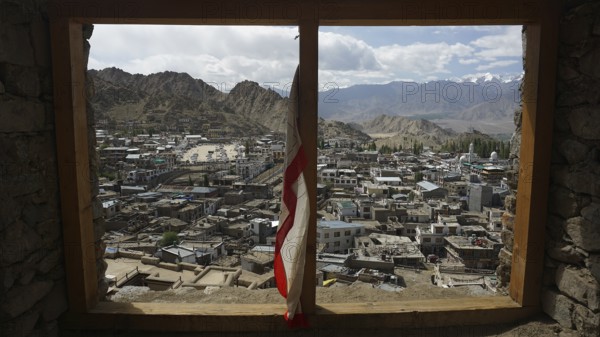 View through a window of Leh Palace over Leh in mountainous landscape with cloudy sky, Ladakh, northern India, Himalayas, India