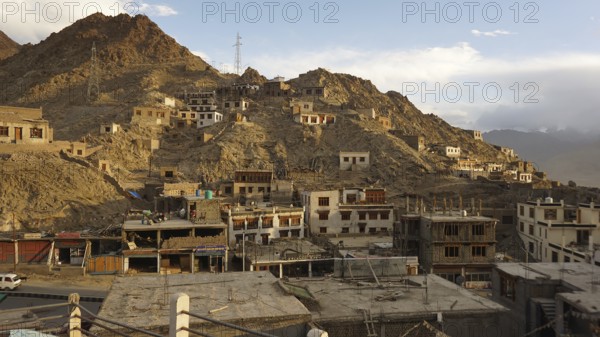 Mountain settlement with buildings built close together and rocky slopes under clear skies, Leh, Ladakh, North India, Himalayas, India