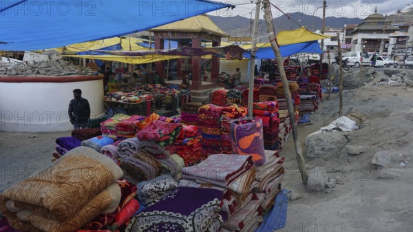 Lively market scene with colorful blankets and textile stalls, Leh, Ladakh, North India, Himalayas, India