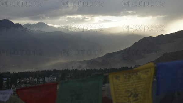 Prayer flags in foreground, mountains in sunset haze, Leh, Ladakh, North India, Himalayas, India